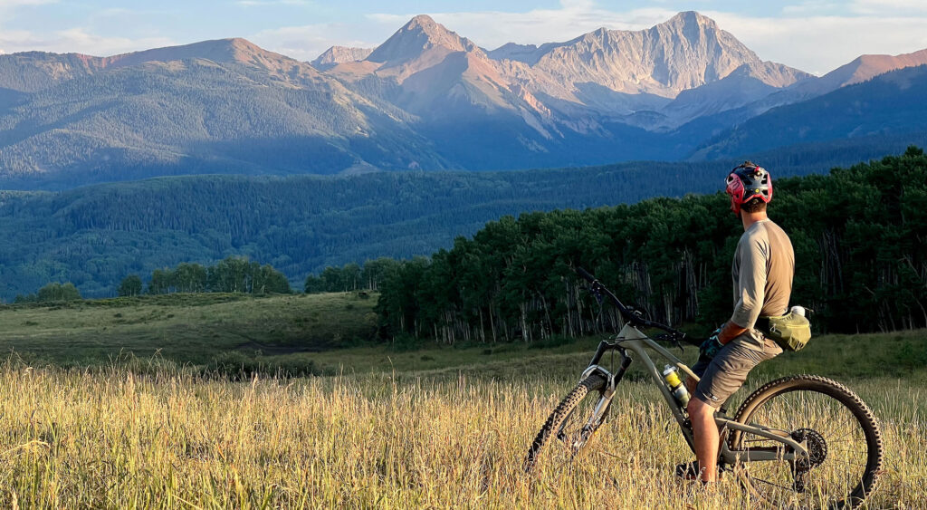 A mountain biking pauses on ride overlooking Capital Peak